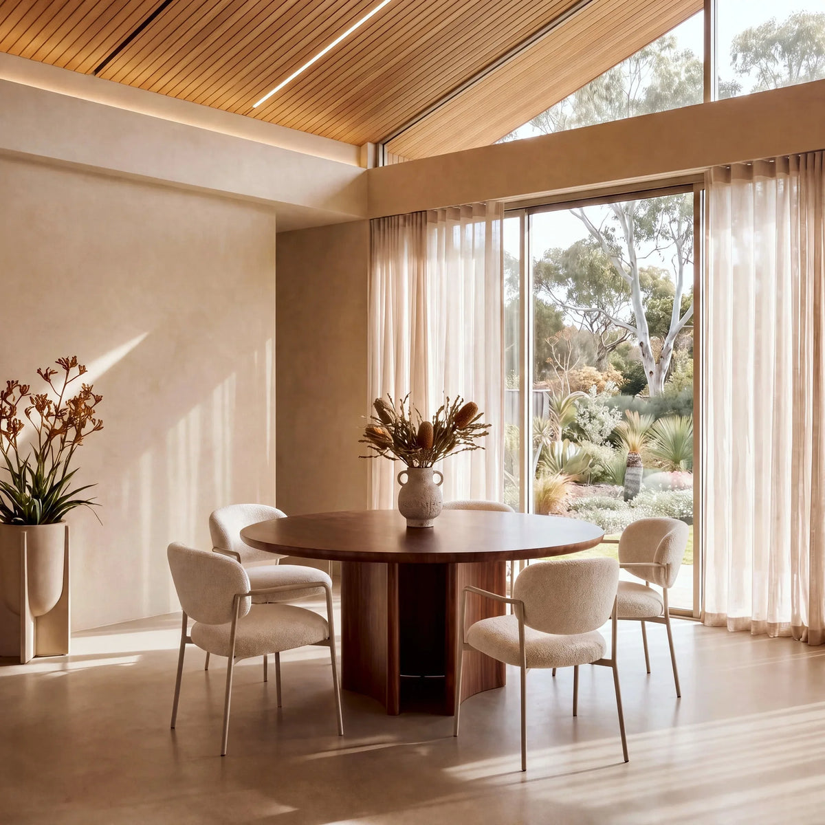 Clover Walnut Wood Round Dining Table – in a bright dining room with cream chairs